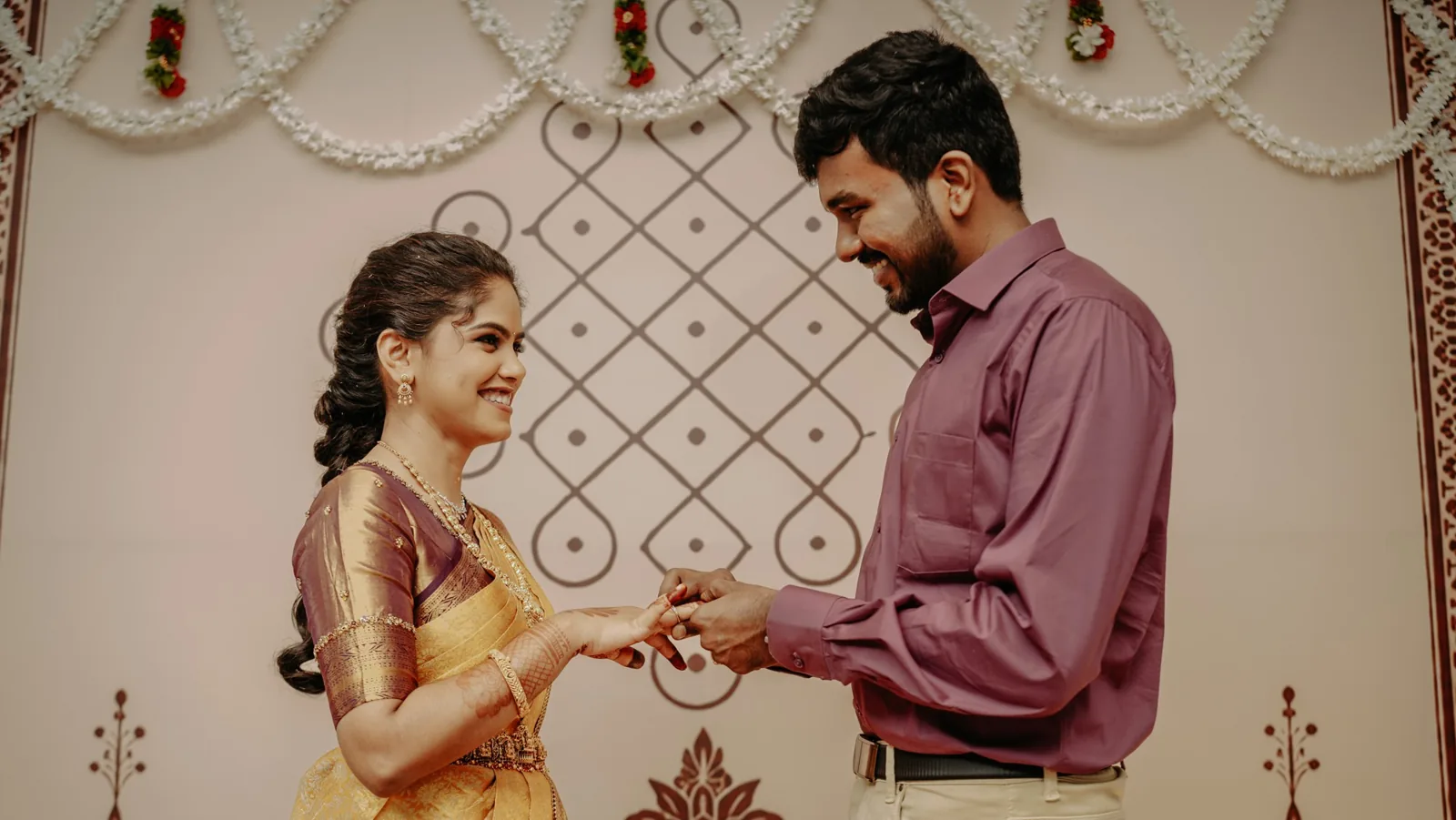 The couple smiling at each other during the ring exchange